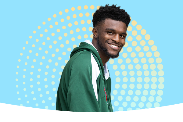 Male student smiling with a yellow green gradient circle in the back